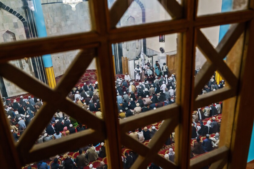 A view from a window above of a mosque crowded with men