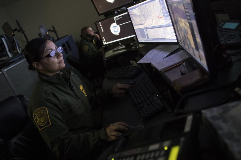 NOGALES, ARIZONA -- FRIDAY, MARCH 16, 2018: U.S. Border Patrol agent Gabriella Cervantes keeps an eye on displays monitoring information gathered from the Integrated Fixed Towers at a border patrol facility in Nogales, Arizona, on March 16, 2018. (Brian van der Brug / Los Angeles Times)