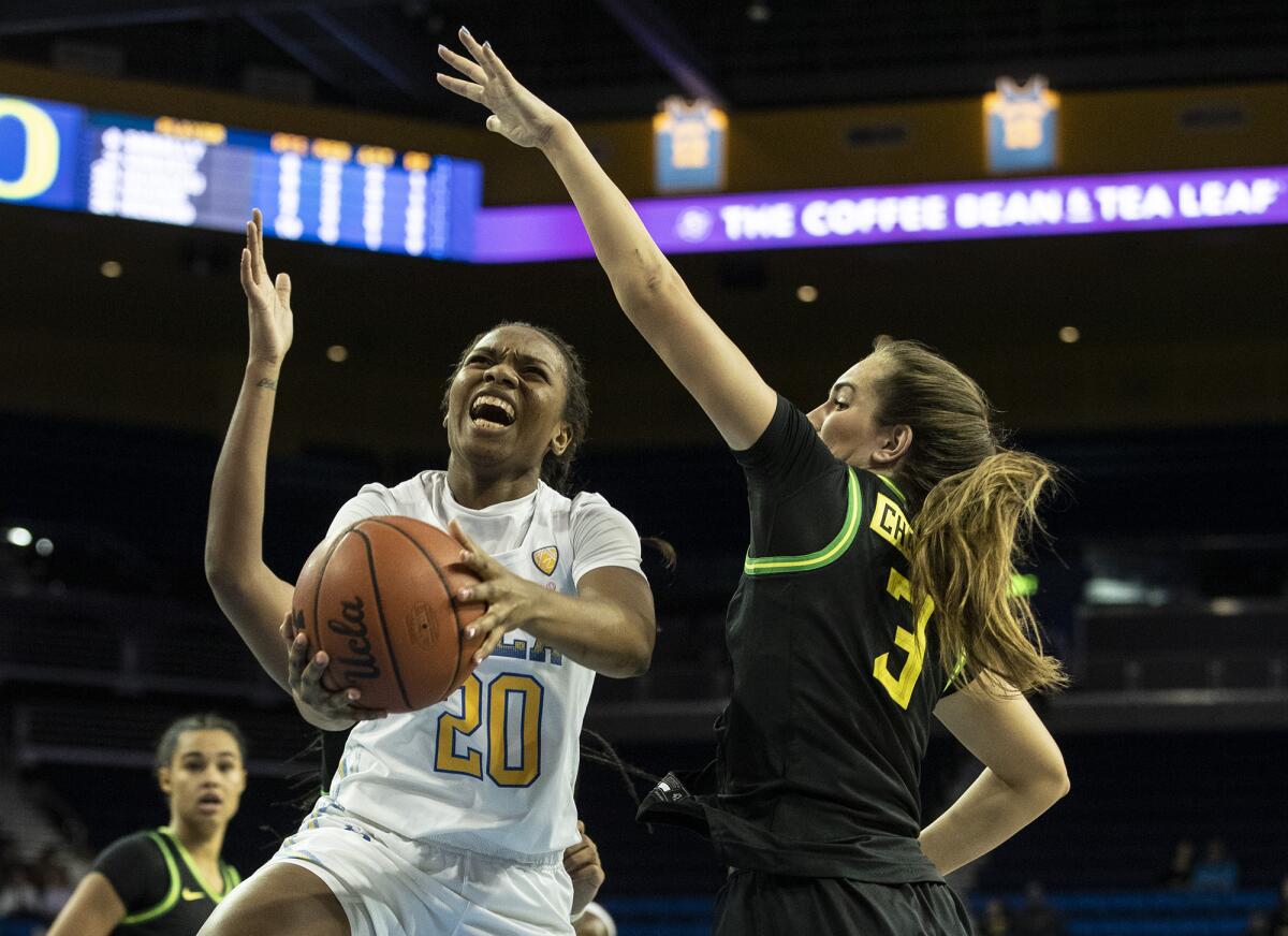 UCLA guard Charisma Osborne drives to the basket against Oregon guard Taylor Chavez during the first half of a game Feb. 14 at Pauley Pavilion.