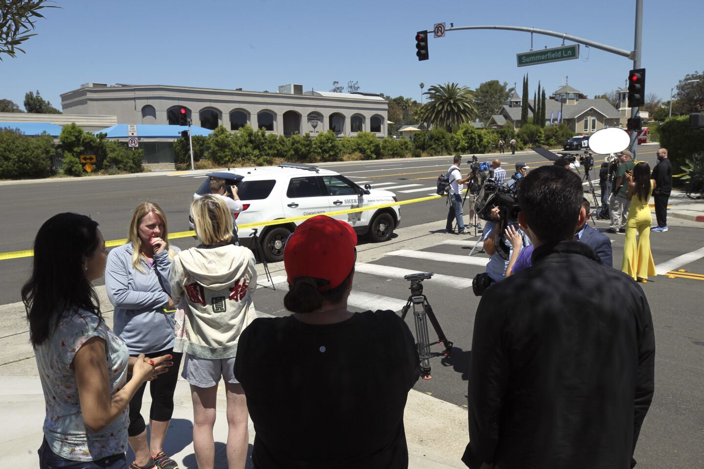 Members of the media and the surrounding community gather near the Altman Family Chabad Community Center in Poway after Saturday's shooting at Chabad of Poway synagogue.
