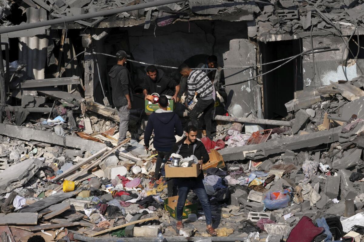 People search through the rubble of a destroyed residential building in Gaza.