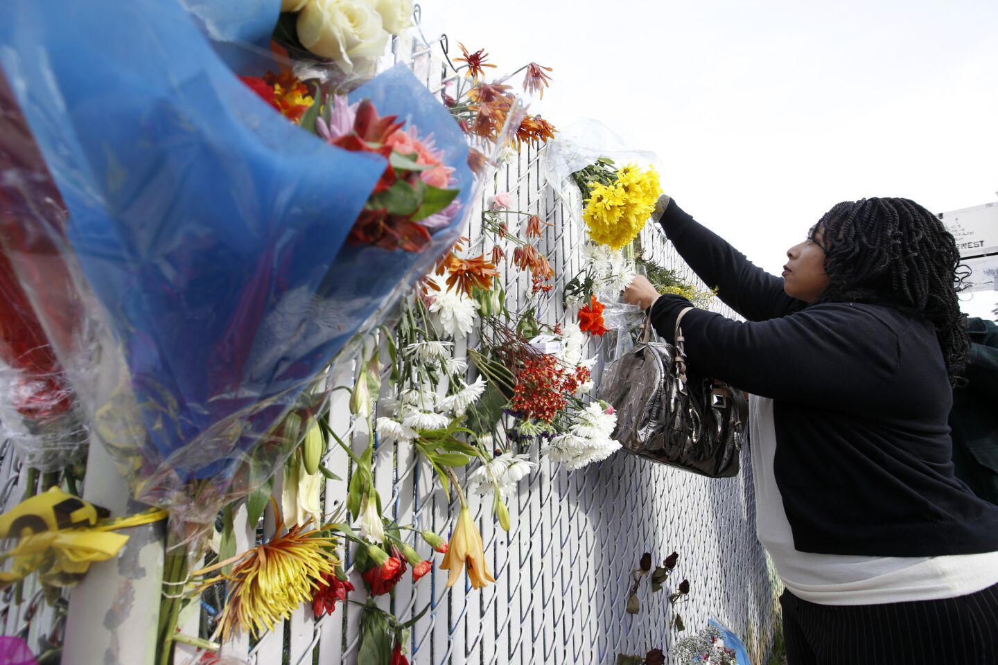 After attending church, Teionna Cunningham of Oakland leaves flowers near the site of the fire.