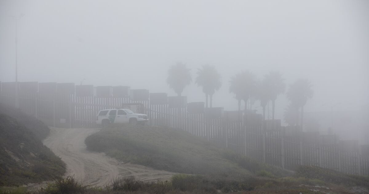 Swimming in ominous fog, a group of immigrants swim to American soil