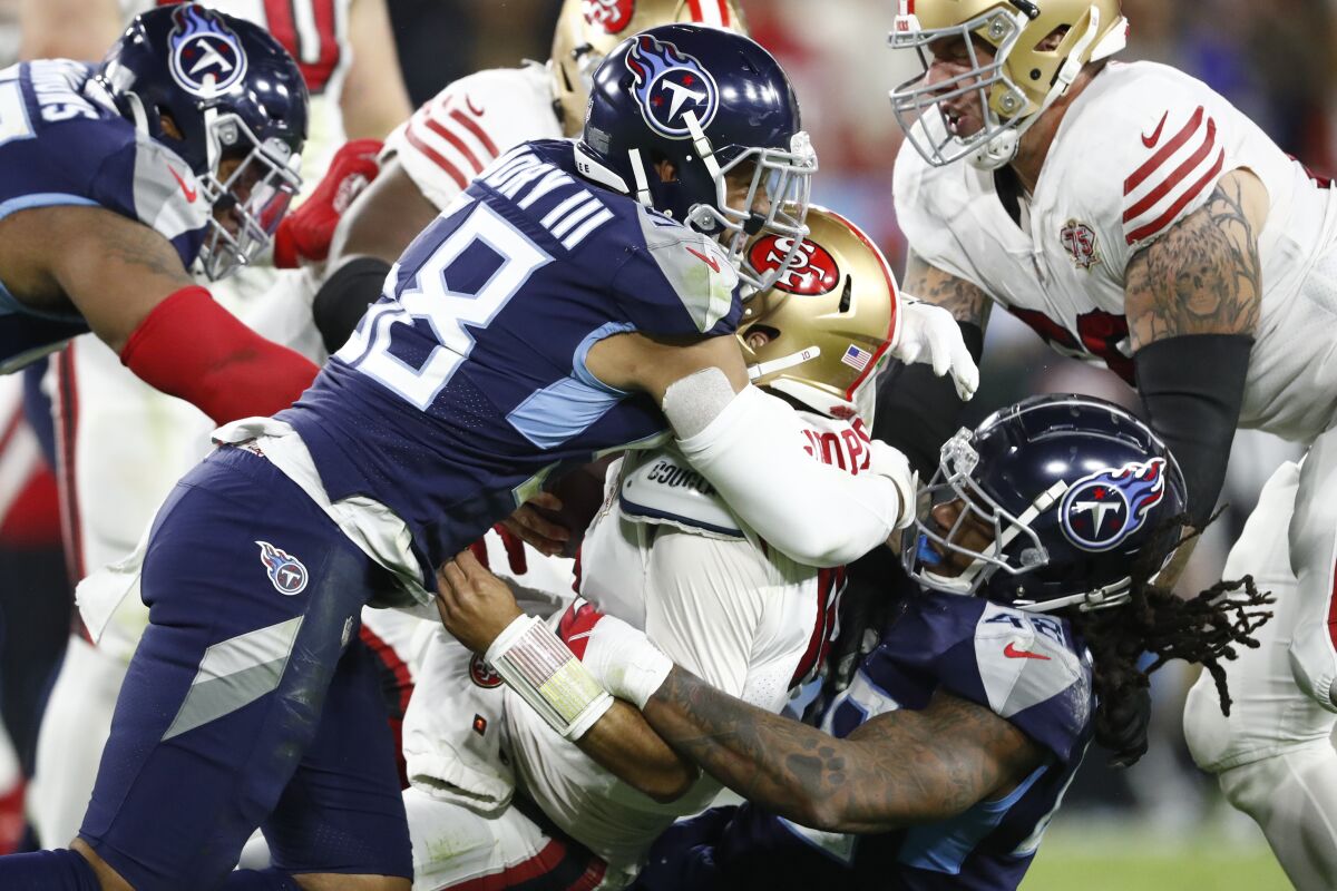San Francisco 49ers quarterback Jimmy Garoppolo is sacked by Tennessee Titans defenders Harold Landry III (58) and Bud Dupree (48) in the second half of an NFL football game Thursday, Dec. 23, 2021, in Nashville, Tenn. (AP Photo/Wade Payne)