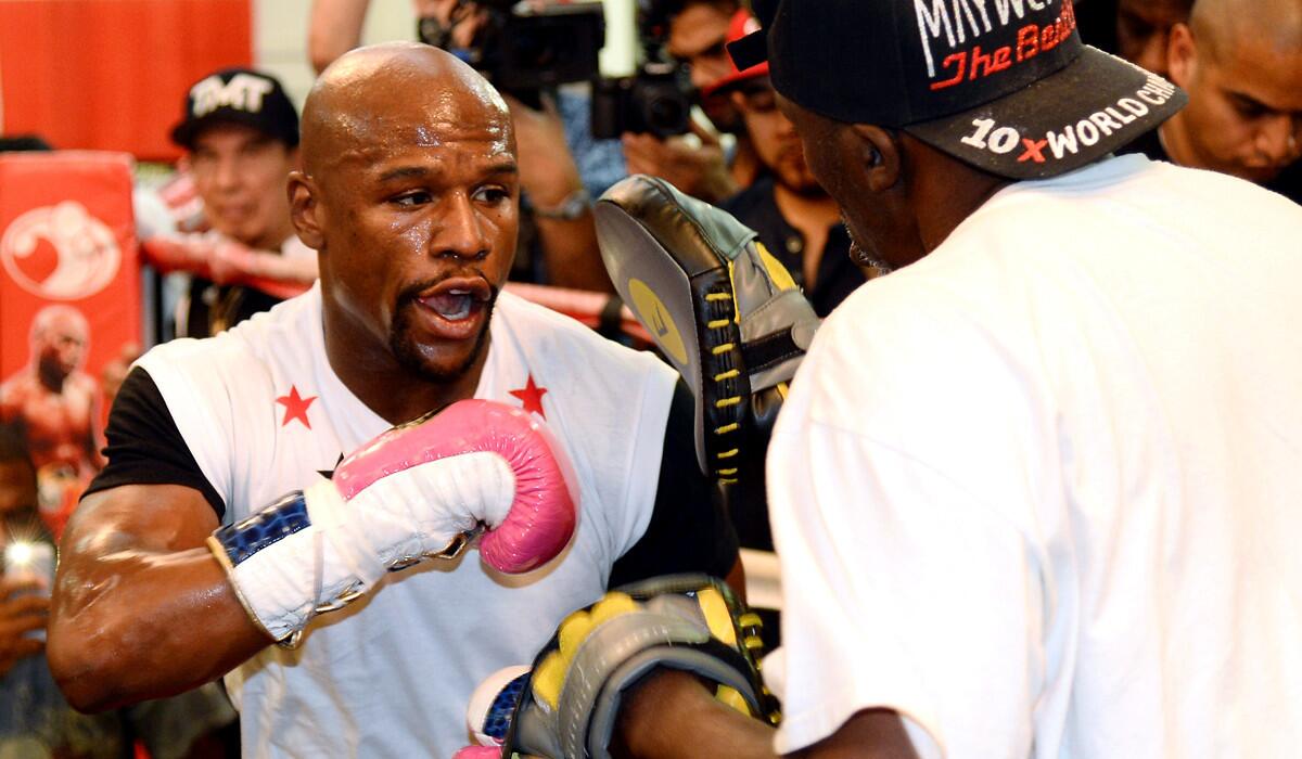 Floyd Mayweather Jr. works out with his trainer and uncle Roger Mayweather at his boxing club in Las Vegas on Tuesday.