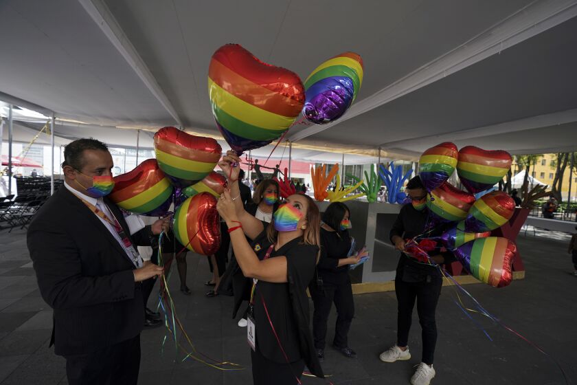 FILE - Mexican Civilian registration office workers decorate with heart-shaped, rainbow colored balloons for a same-sex mass wedding ceremony, in Mexico City, June 24, 2022. Lawmakers in the border state of Tamaulipas voted Wednesday night, Oct. 26, 2022, to legalize same-sex marriages, becoming the last of Mexico's 32 states to authorize such unions. (AP Photo/Fernando Llano, File)
