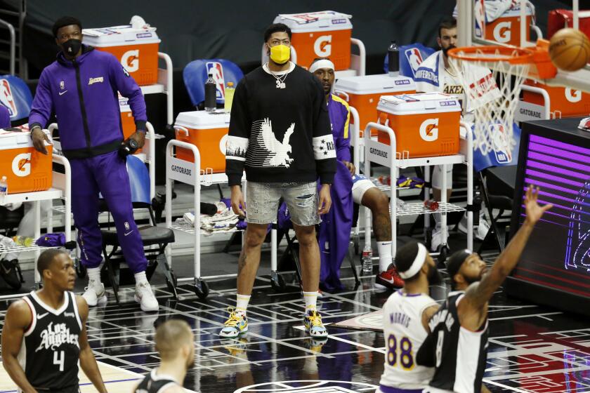 LOS ANGELES, CA - APRIL 04: Los Angeles Lakers forward Anthony Davis (3), injured, looks on from the sideline while the Lakers play the LA Clippers in the first quarter at the Staples Center on Sunday, April 4, 2021 in Los Angeles, CA. (Gary Coronado / Los Angeles Times)