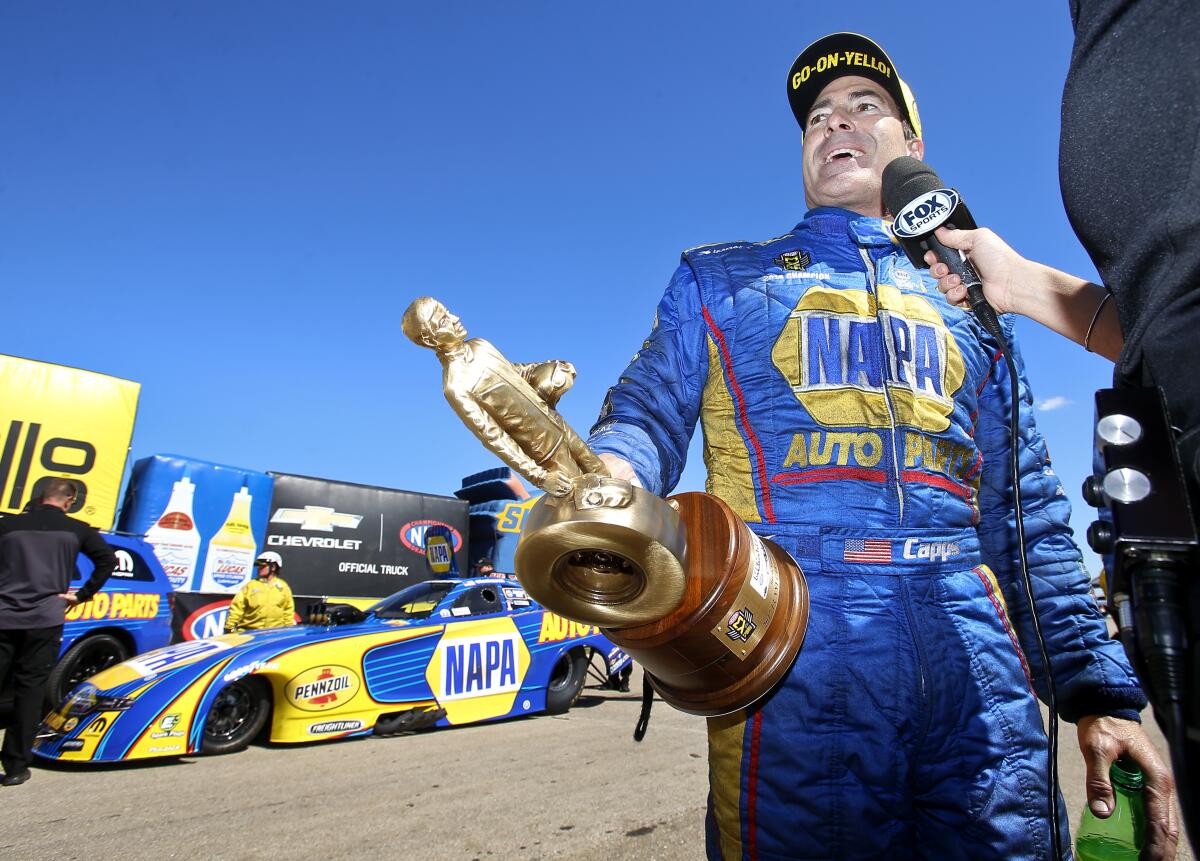 FILE- In this May 21, 2017, file photo, funny car driver Ron Capps is interviewed by Fox Sports after winning the NHRA Heartland Nationals in Topeka, Kan. Don Schumacher Racing has won the last 14 events in the NHRA's Funny Car division. It's a record for the racing series. (Chris Neal/The Topeka Capital-Journal via AP, File)