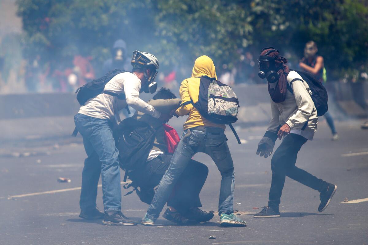 Un grupo de manifestantes se enfrenta con la policía durante una protesta en contra del Gobierno venezolano, en Caracas.