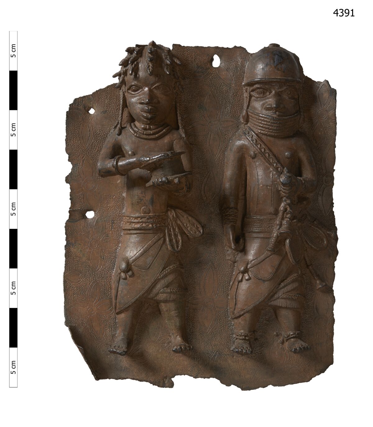 A brass plaque depicts a war chief and a royal military priest carrying a leather gift box. 
