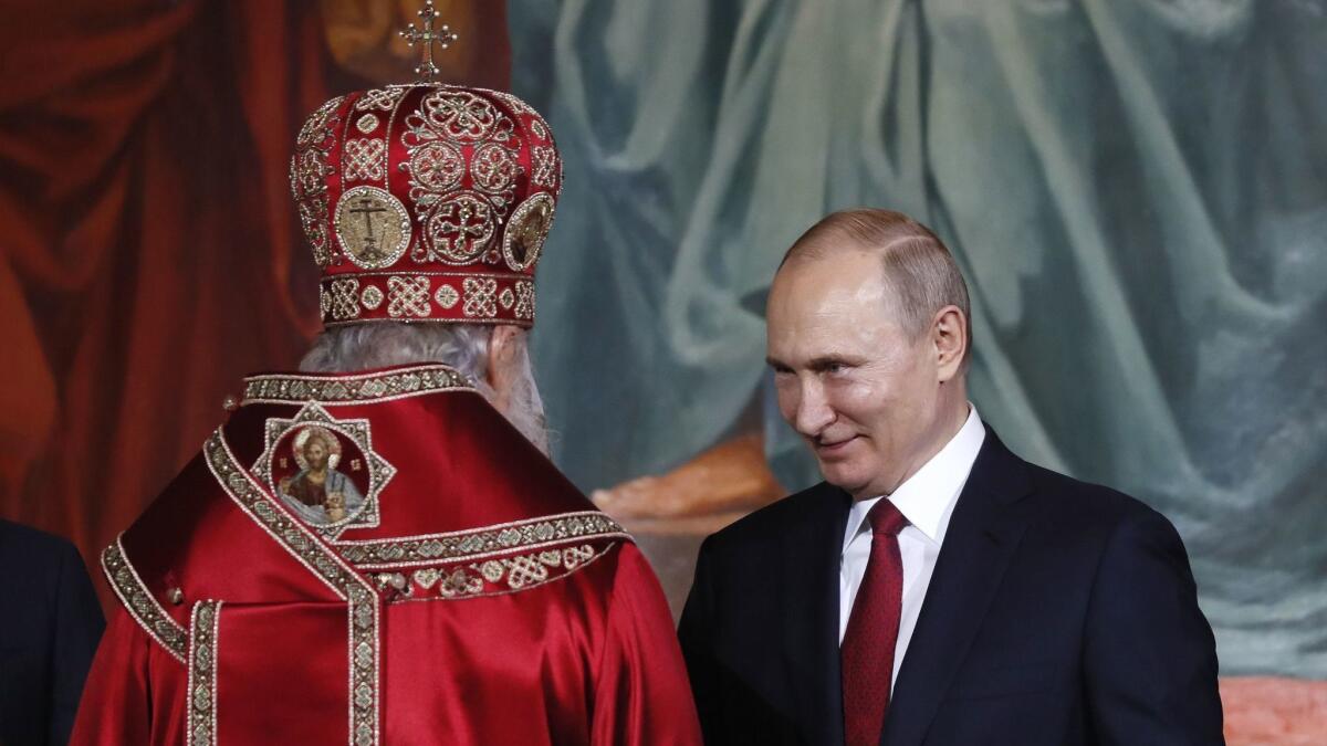 Patriarch Kirill of Moscow and All Russia, left, greets Russian President Vladimir Putin during the Orthodox Easter holiday service at Christ the Savior Cathedral in Moscow on April 28.