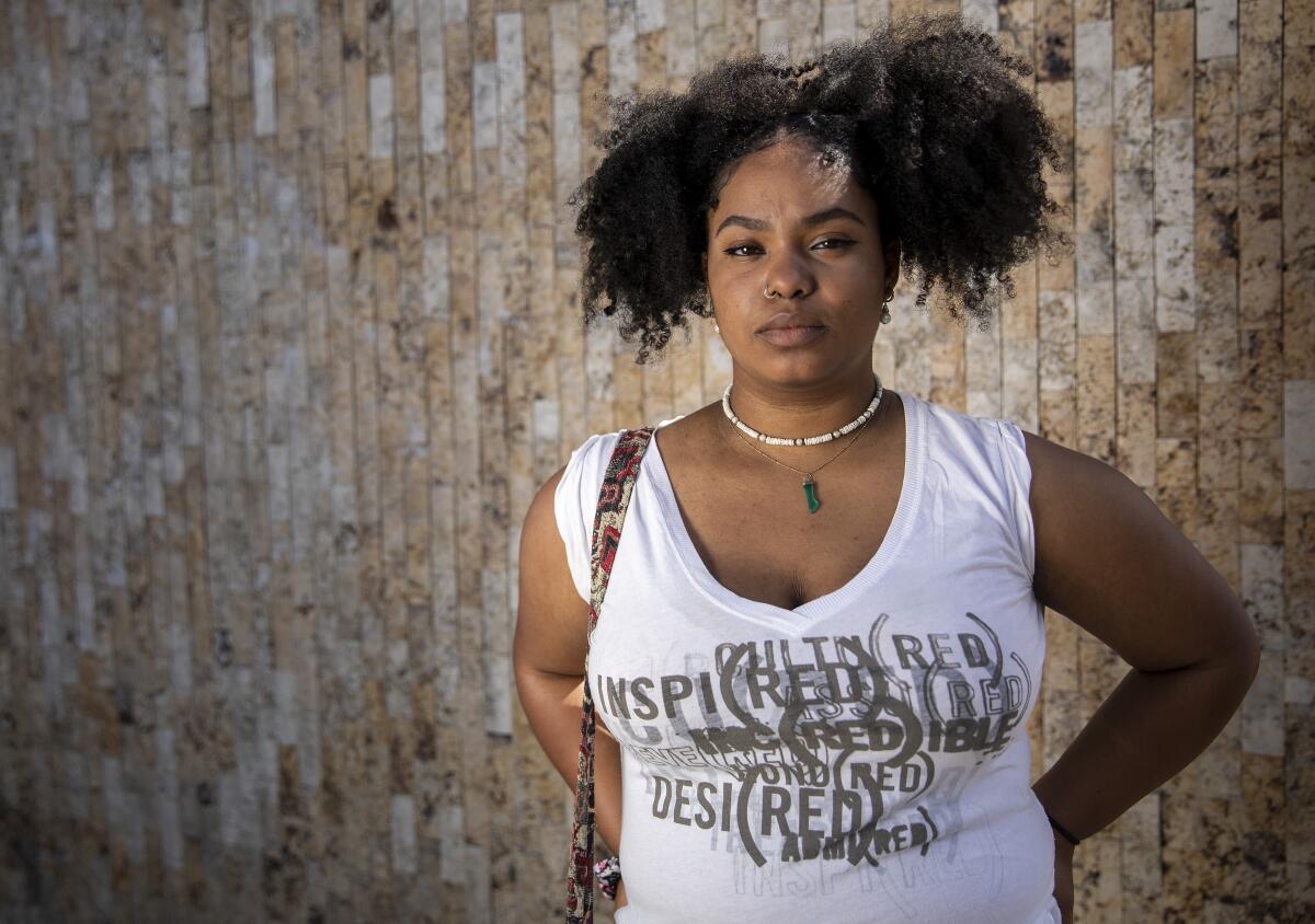 Thandiwe Abdullah poses in front of a wall.