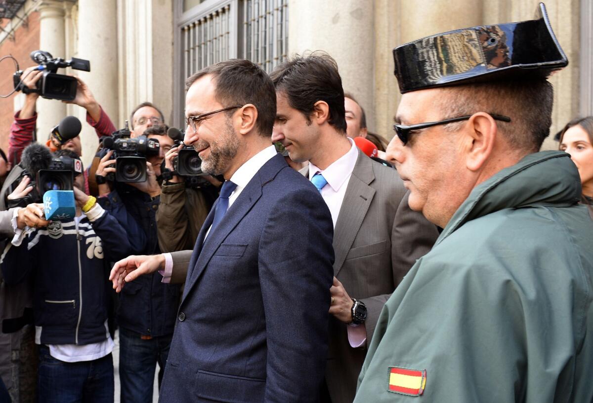 U.S. Ambassador to Spain James Costos, left, leaves the Spanish Foreign Ministry in Madrid.