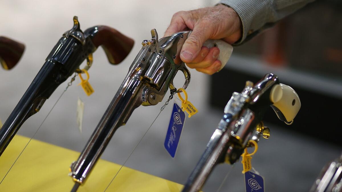 An attendee inspects a handgun during the NRA Annual Meeting and Exhibits in Houston, Texas on May 3, 2013.