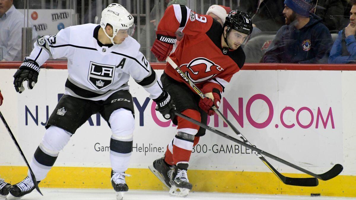 Kings forward Dustin Brown, left, challenges New Jersey Devils defenseman Will Butcher for the puck in a game Dec. 12.