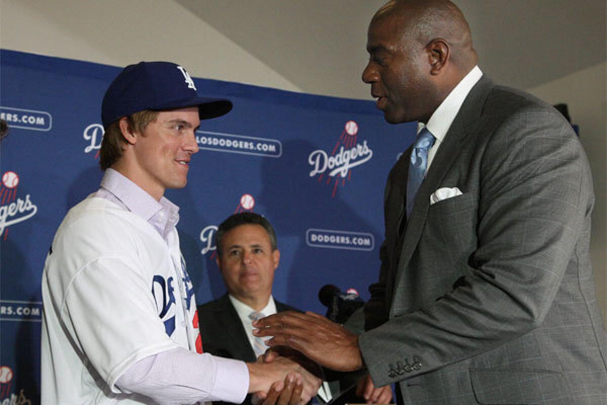 Dodgers co-owner Magic Johnson welcomes new pitcher Zack Greinke at a news conference at Dodger Stadium last month.