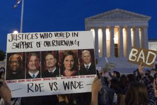 FILE - Nikki Tran holds up a sign with pictures of U.S. Supreme Court Justices, from left, Clarence Thomas, Brett Kavanaugh, Samuel Alito, Amy Coney Barrett and Neil Gorsuch, as demonstrators protest outside of the Supreme Court, May 3, 2022, in Washington. On Tuesday, Jan. 10, 2023, months after the unprecedented leak of the Supreme Court draft opinion that overturned Roe v. Wade, lawmakers in North Dakota considered — and struck down — a bill to criminalize court leaks. (AP Photo/Jacquelyn Martin, File)