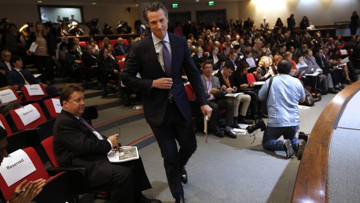 California Gov. Gavin Newsom walks to the auditorium stage to present his first state budget during a news conference on Thursday in Sacramento.