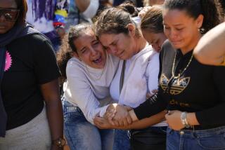 A sister of miner Santiago Mora, left, cries with other relatives as he is buried at the cemetery in La Paragua, Bolivar state, Venezuela, Thursday, Feb. 22, 2024. The collapse of an illegally operated open-pit gold mine in central Venezuela killed at least 14 people and injured several more, state authorities said Wednesday, as some other officials reported an undetermined number of people could be trapped. (AP Photo/Ariana Cubillos)