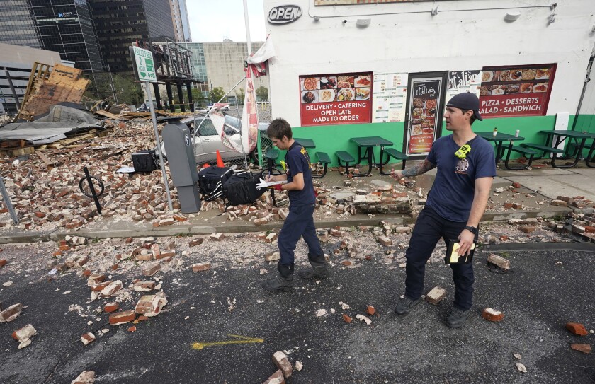 New Orleans firefighters look through debris after a building collapsed from the effects of Hurricane Ida