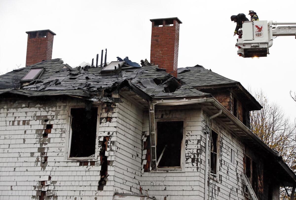 Firefighters examine the scene of a fatal apartment building fire Saturday in Portland, Maine.