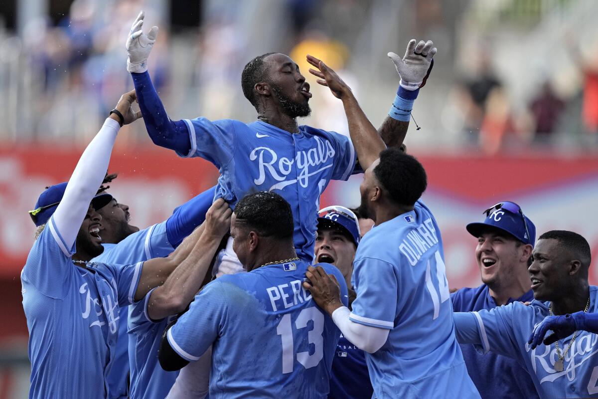 Samad Taylor, top center, celebrates with his Royals teammates after he hit a game-winning single in the ninth inning.