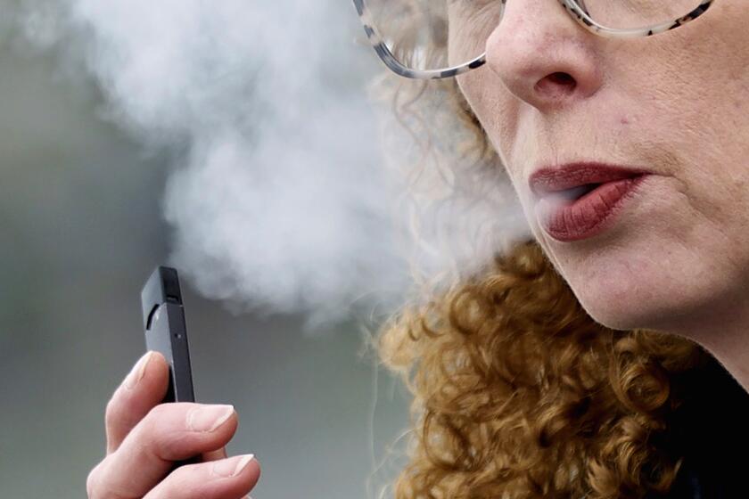 FILE — A woman exhales while vaping from a Juul pen e-cigarette in Vancouver, Wash., April 16, 2019. Federal health officials on Thursday,June 23, 2022 ordered Juul to pull its electronic cigarettes from the U.S. market, the latest blow to the embattled company widely blamed for sparking a national surge in teen vaping. (AP Photo/Craig Mitchelldyer, File)