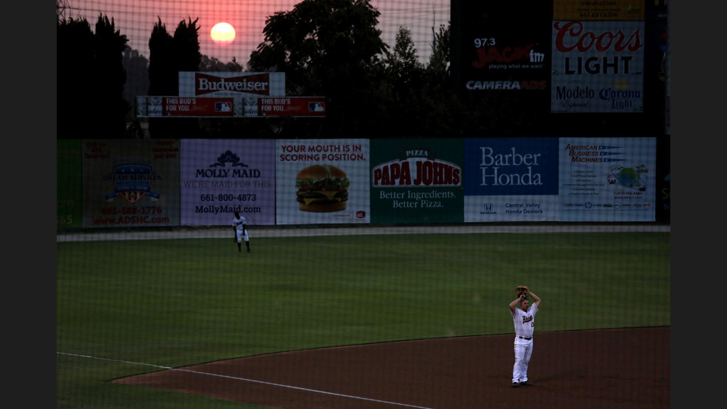 The sun slowly sets over Sam Lynn Ballpark as the Blaze's Joe DeCarlo stretches before a game against the Ports.
