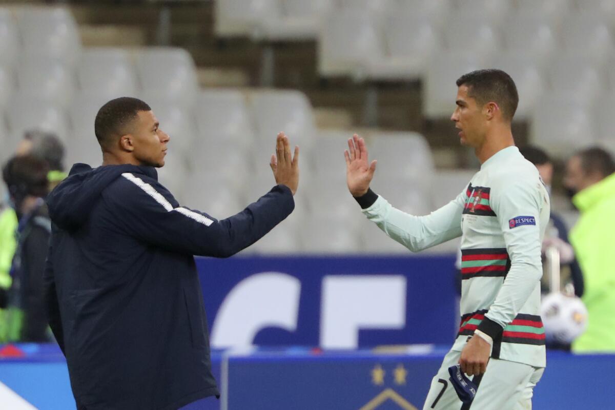 ARCHIVO - el francés Kylian Mbappé y el portugués Cristiano Ronaldo se saludan 