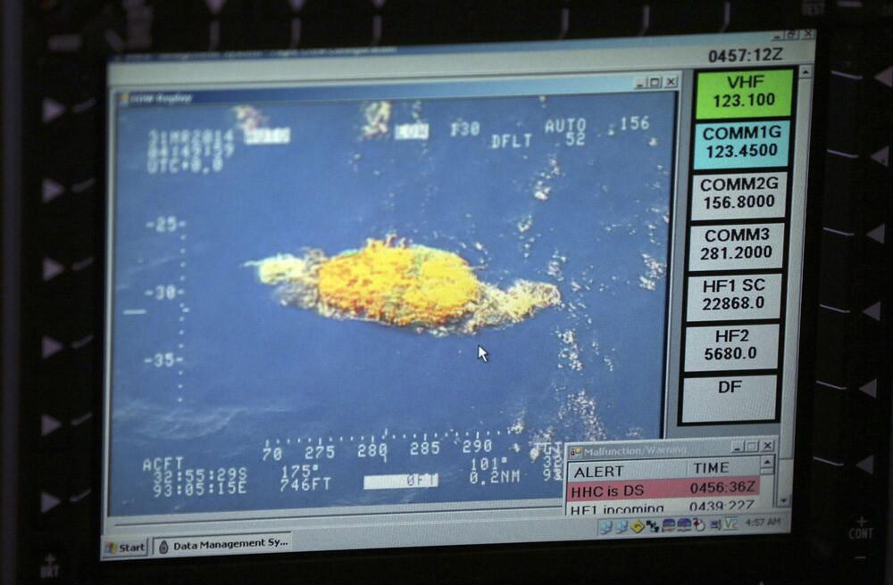 A picture taken off a computer monitor aboard a Royal New Zealand P3 Orion shows a piece of unknown debris floating just under the water as the search continues for missing Malaysia Airlines flight MH370 on March 31.