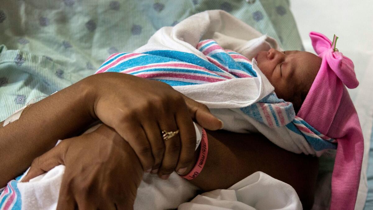 Marrielle Andrews sleeps in her mother's arms at Bon Secours DePaul Medical Center in Norfolk, Va. on May 2.