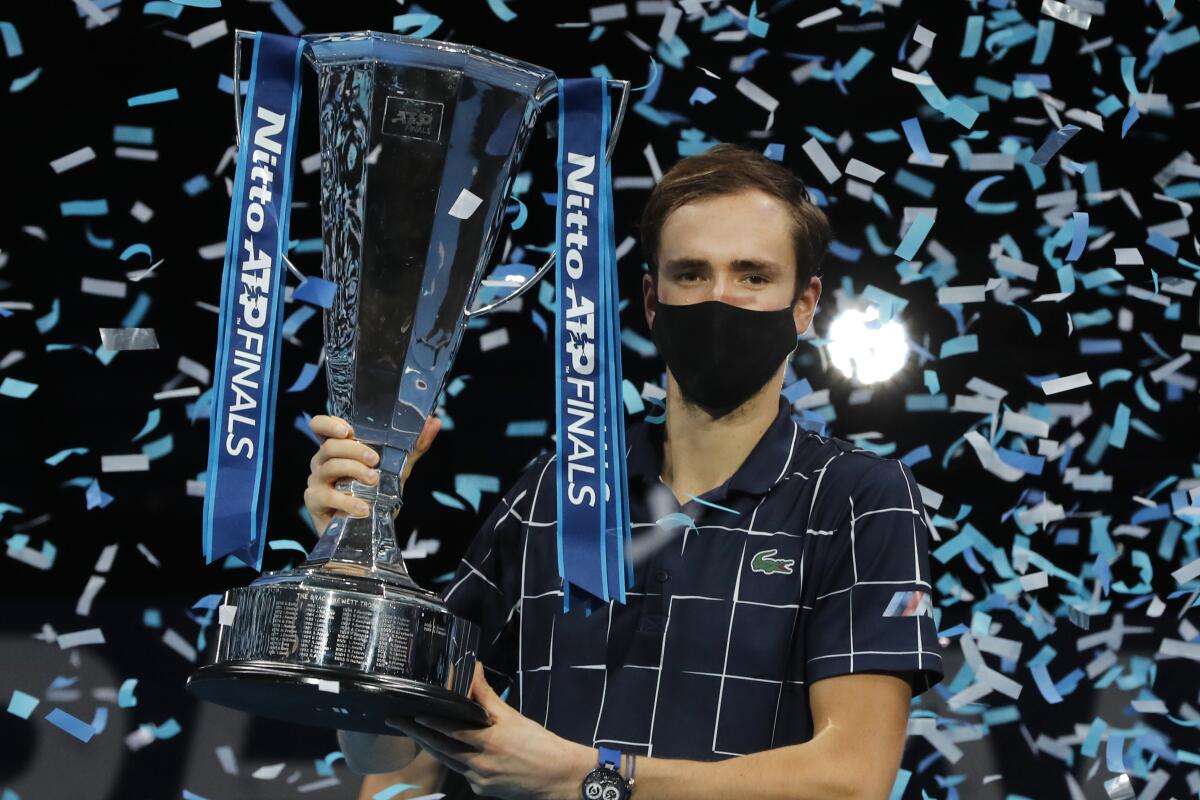 Daniil Medvedev of Russia holds up the winners trophy as confetti falls after defeating Dominic Thiem.