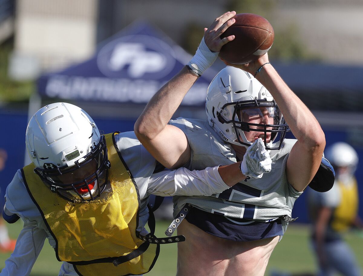 Flintridge Prep's Ben Grable, who is tall, had to lean over and grab this pass over the head of his teammate as the team practices plays at pre-season football practice at Flintridge Prep on Monday, August 19, 2019.