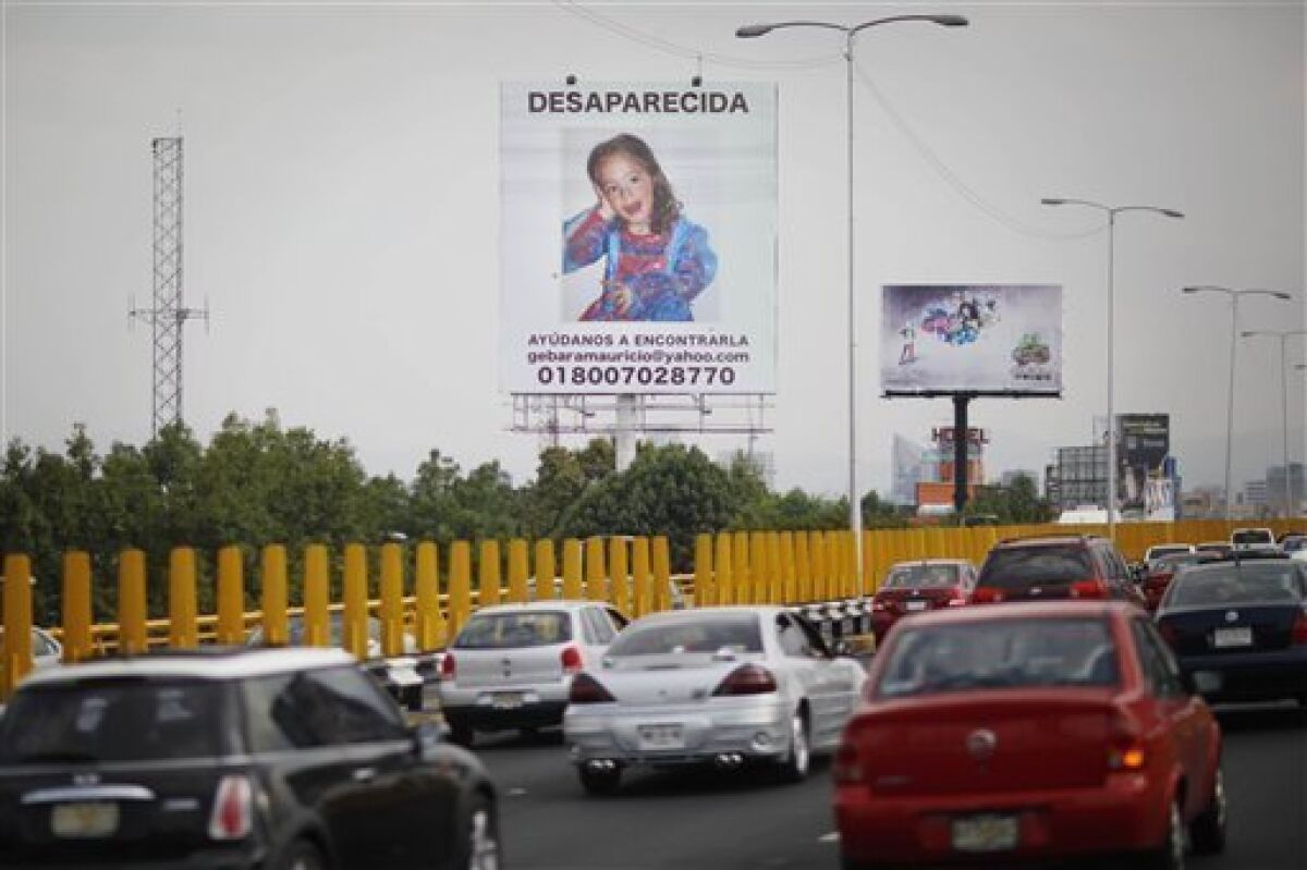Vehicles pass a billboard of Paulette Gebara Farah with the words in Spanish "Disappeared, help us find her" in Mexico City, Wednesday, March 31, 2010. The body of Farah, a disabled 4-year-old girl, was found Wednesday in her own bedroom, 10 days after her wealthy parents reported her missing and stirred nationwide sympathy with a public campaign to find her. (AP Photo/Alexandre Meneghini)