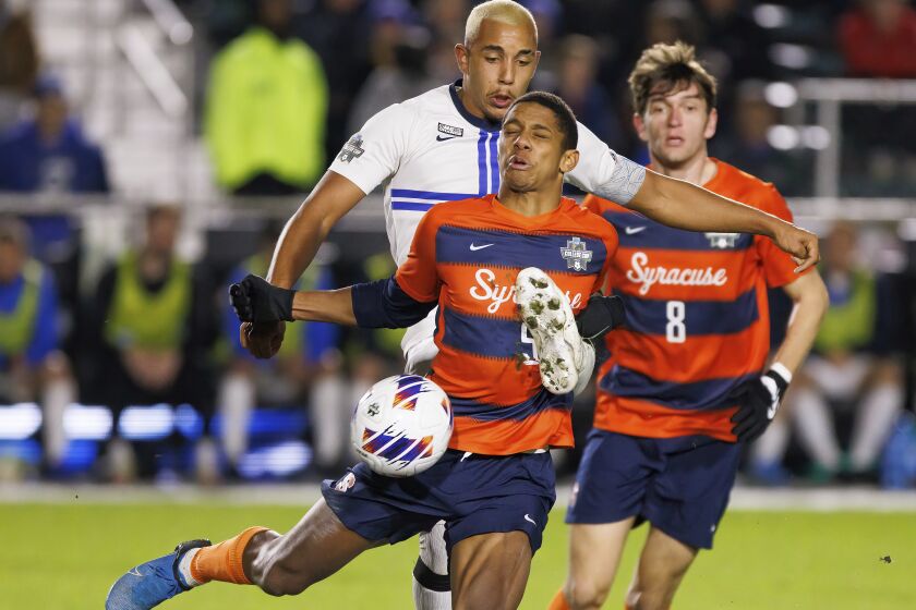 Creighton's Charles Auguste, rear left, and Syracuse's Amferny Sinclair (5) compete for the ball during the second half of an NCAA men's soccer tournament semifinal in Cary, N.C., Friday, Dec. 9, 2022. (AP Photo/Ben McKeown)