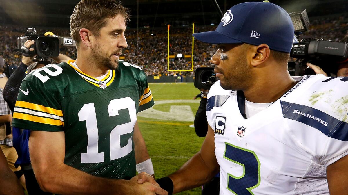 Quarterbacks Aaron Rodgers of the Green Bay Packers, left, and Russell Wilson of the Seattle Seahawks shake hands following their game Sunday night at Lambeau Field.