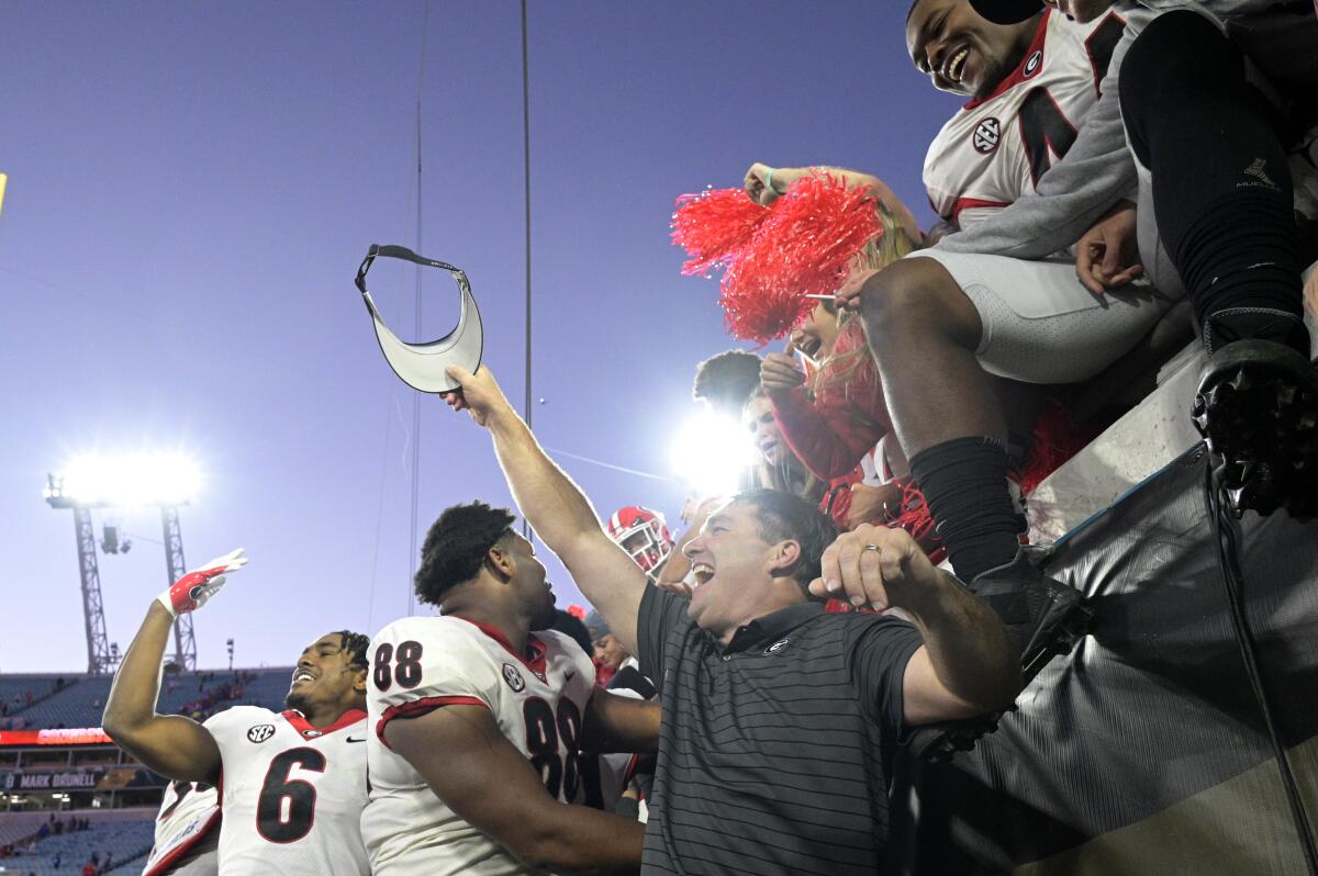 Georgia coach Kirby Smart, center, celebrates with players and fans after the Bulldogs defeated Florida on Oct. 30, 2021.