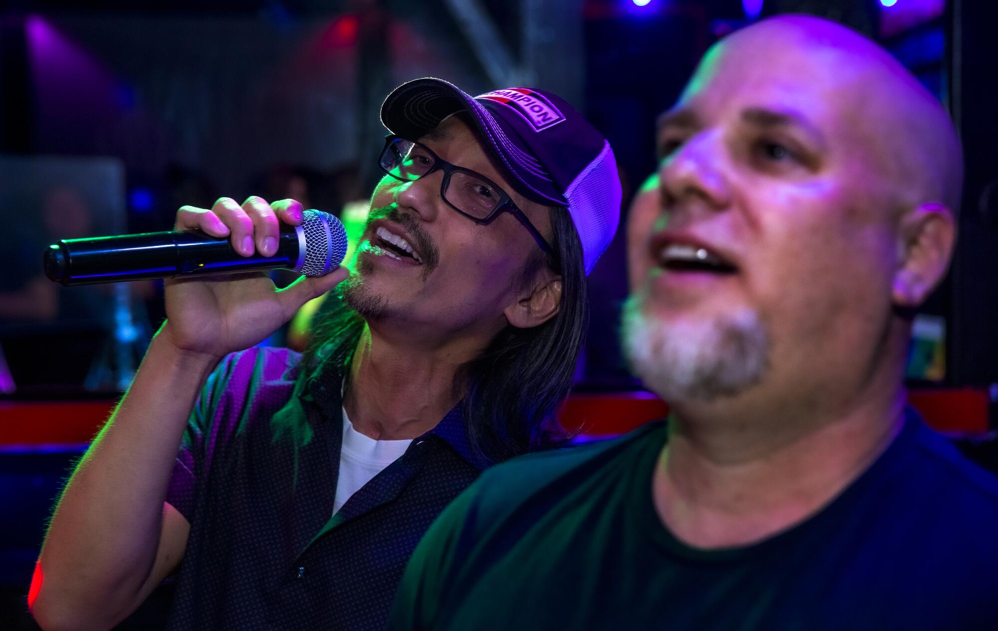 Mark Chou, left, and his partner Mark Lanza sing karaoke.