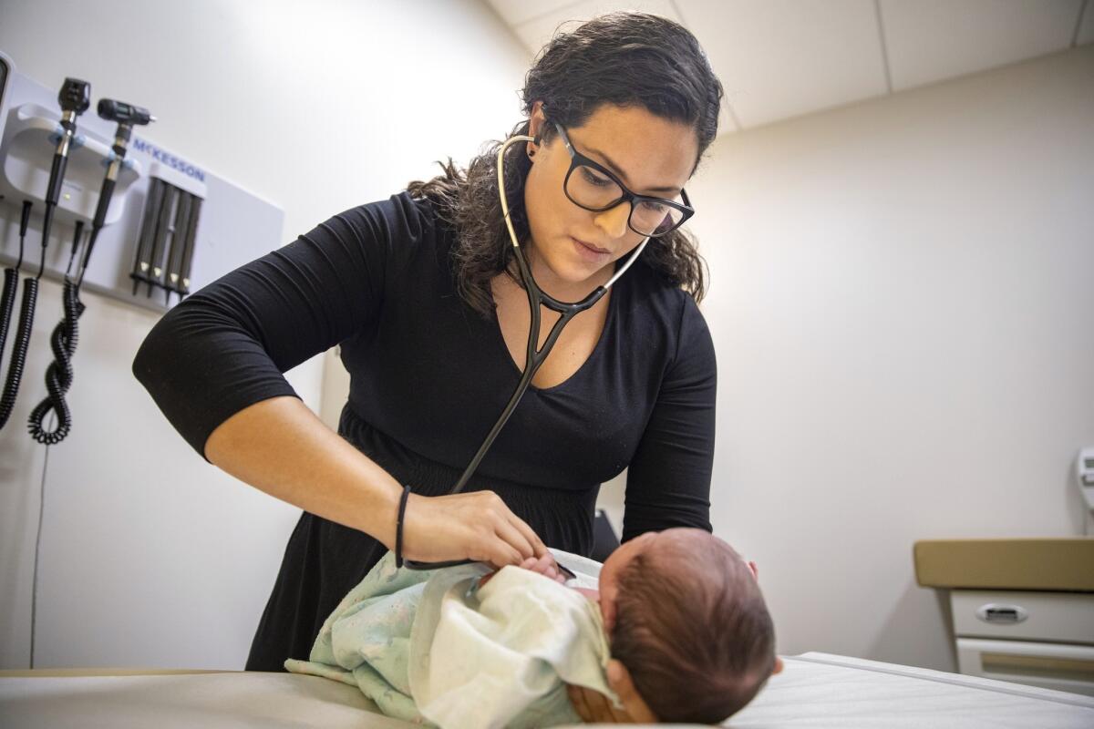 En esta foto del martes 13 de agosto de 2019, la doctora Jasmine Saavedra, una pediatra en la clínica Esperanza Health Centers, cuyos padres emigraron de México en la década de 1980, examina a Alondra Márquez, una bebé recién nacida en su clínica, en Chicago. (Foto AP/Amr Alfiky)