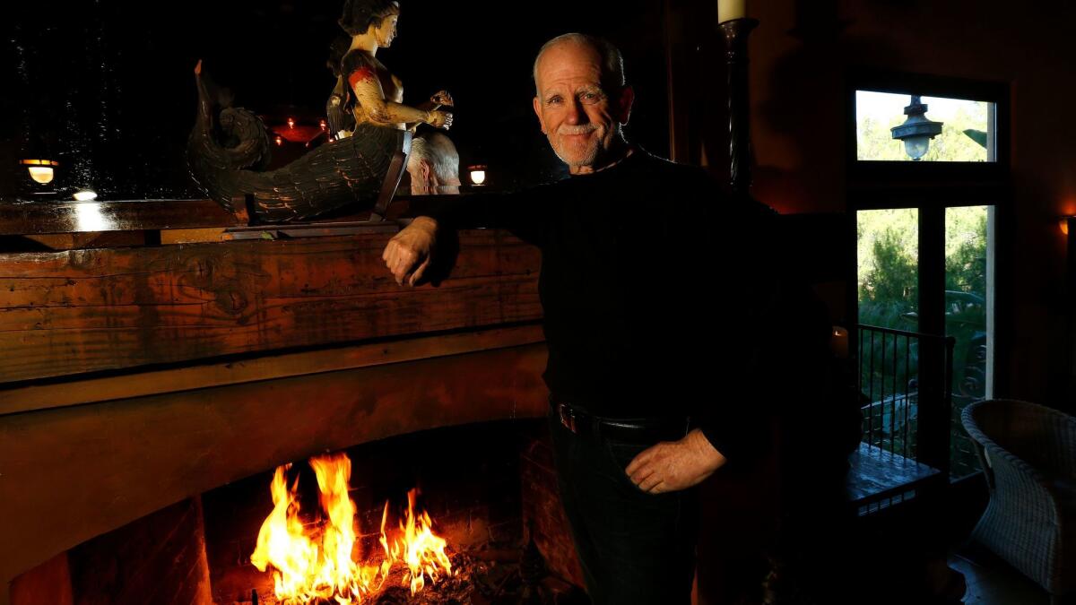 Builder-owner Bill Buerge at the fireplace he restored.