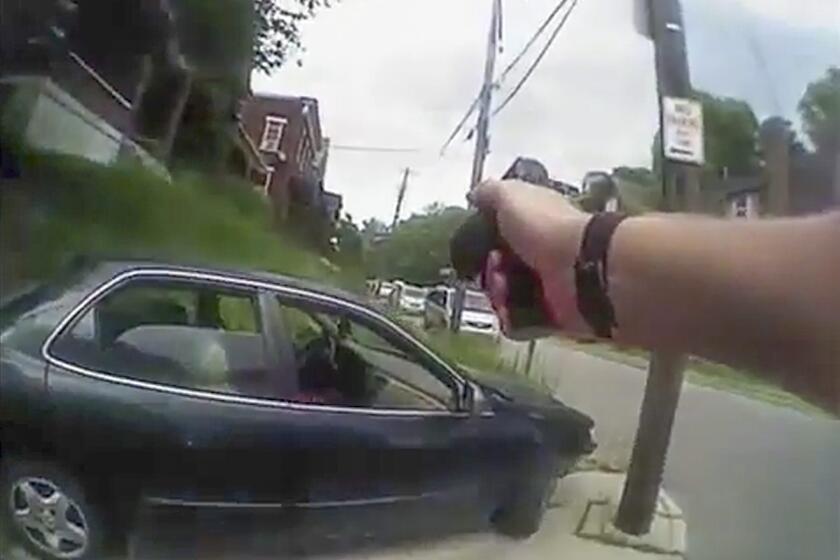 A frame grab from a body-cam video shows University of Cincinnati Police Officer Ray Tensing approaching Samuel DuBose's vehicle right after Tensing shot him during a traffic stop.