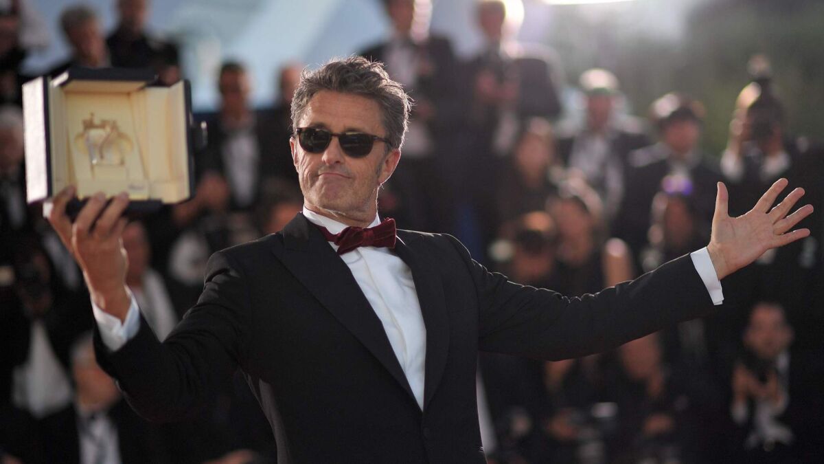Polish director Pawel Pawlikowski shows off his director prize for the film "Zimna Wojna (Cold War)" at the 71st Cannes Film Festival in France on May 19.