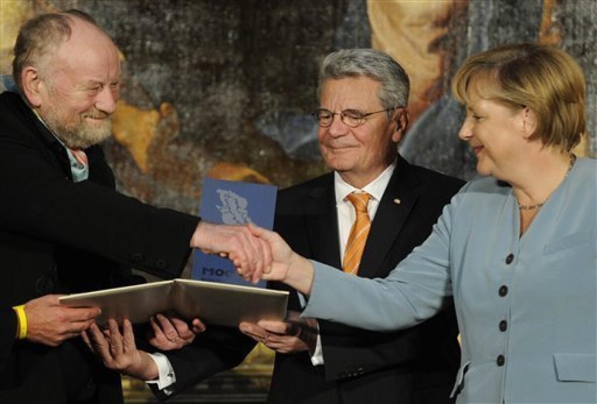 Danish cartoonist Kurt Westergaard, left, is congratulated on his prize by German Chancellor Angela Merkel, right, and the former head of the state-funded body which manages the archives of the former East German secret police Stasi Joachim Gauck, center, after receiving the M100 Media Prize 2010 in Potsdam near Berlin, eastern Germany, Wednesday, Sept. 8, 2010. Westergaard drew the most controversial of 12 caricatures of the Prophet Mohammed, first published in a Danish newspaper in 2005, which many Muslims considered offensive. (AP Photo/Odd Andersen, pool)