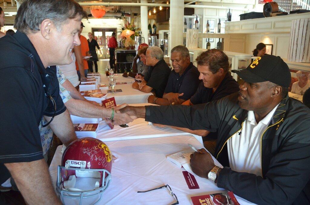 Former football players, including Charle Young, right, sign books during the My Best Day book signing held Saturday at The Cannery Restaurant.