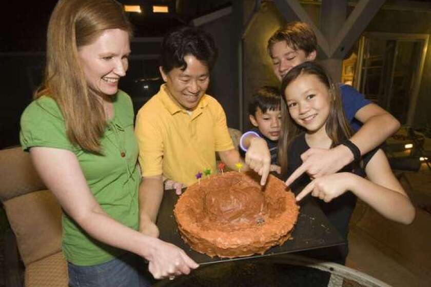 David Oh with his wife, Bryn, left, and their sons Devyn and Braden and daughter Ashlyn, show their Mars cake during a late-night dinner at their home in La Canada Flintridge. David, a Jet Propulsion Laboratory engineer on NASA's Mars Science Laboratory mission, has worked on Mars time during the Curiosity rover mission. His family joined him on the schedule for a month.