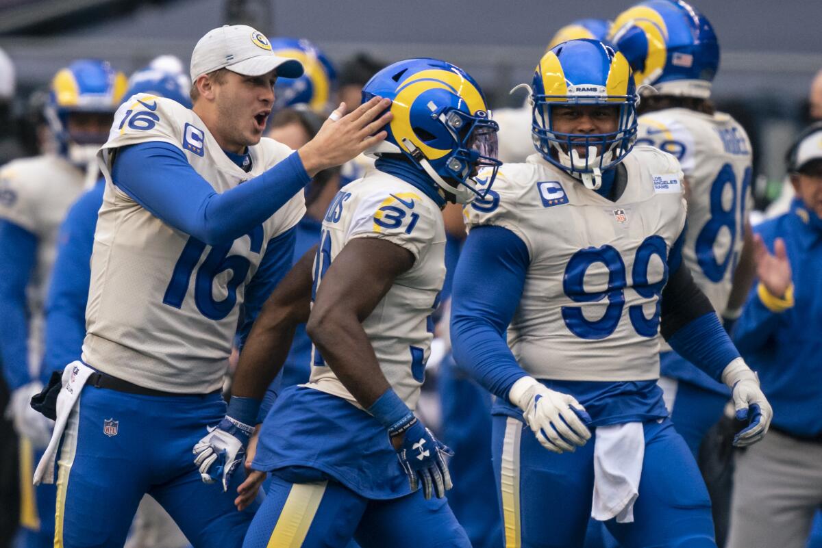 Rams quarterback Jared Goff, left, and defensive lineman Aaron Donald (99) celebrate with defensive back Darious Williams.