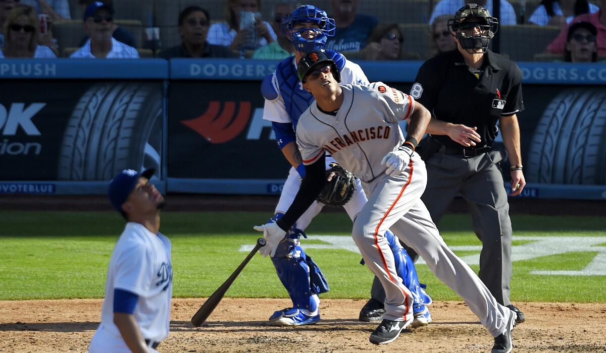 San Francisco Giants' Justin Maxwell hits a two-run home run as Los Angeles Dodgers starting pitcher Carlos Frias, left, catcher Yasmani Grandal, second from left, and home plate umpire Chris Guccione watch on Saturday.