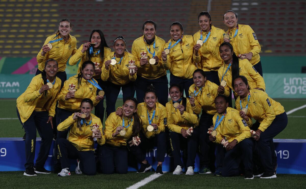 Colombia players hold their gold medals after defeating Argentina in the women's soccer final match at the Pan American Games in Lima, Peru, Friday, Aug. 9, 2019. (AP Photo/Juan Karita)