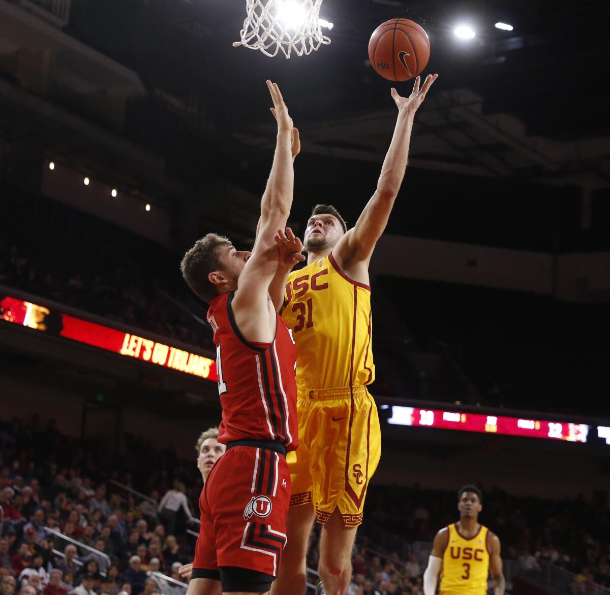 USC forward Nick Rakocevic (31) scores a basket guarded by Utah Utes forward Riley Battin (21) in the first half at the Galen Center on Thursday.