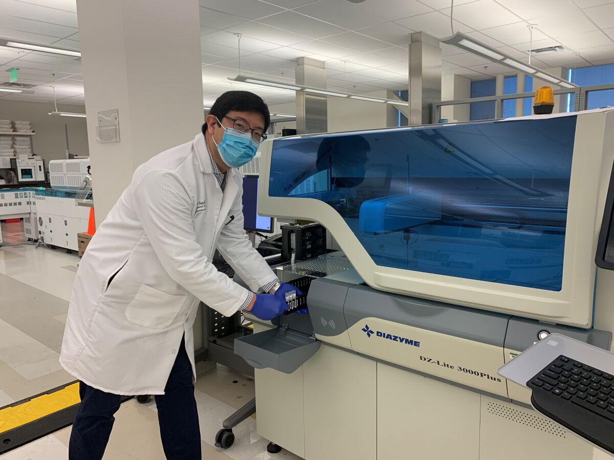 Dr. Ray Suhandynata loads samples for analysis on the Diazyme DZ-Lite 3000Plus analyzer at the UC San Diego Center for Advanced Laboratory Medicine. The instrument measures concentrations of antibodies directed against the coronavirus that causes COVID-19.